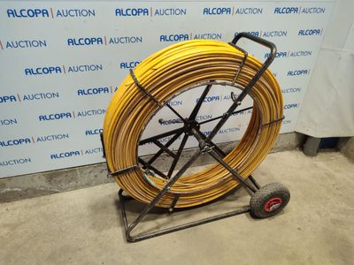 an image of a yellow hose is on a cart in front of a wall