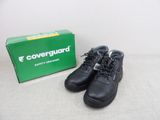 a pair of black boots sitting next to a green box