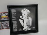framed photograph of a marilyn monroe smoking a cigarette in front of a picture of a car
