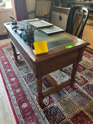 a desk with a glass top and a chair in the room
