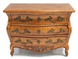 une commode en bois dont les tiroirs sont ornés de sculptures élaborées