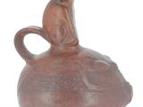 a brown vase with a cat sitting on top of it