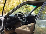 a car with the door open sitting on the side of the road