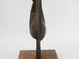 statue of a bird on a wooden base on a white background