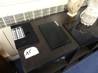 une table noire sur laquelle se trouvent une tablette et un clavier