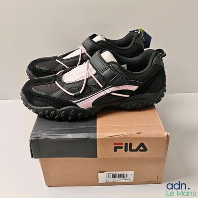 chaussures Fila noires et roses sur une boîte en carton