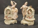 pair of porcelain figurines of a woman and a man on a carriage