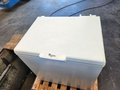 a white refrigerator sitting on a pallet in a warehouse