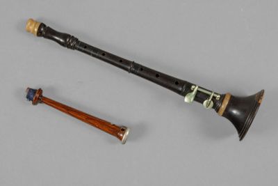 an image of a flute and a wooden stick on a gray surface