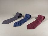 three different colors of ties sitting next to each other on a white surface