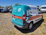a van that is parked in a field with other vehicles