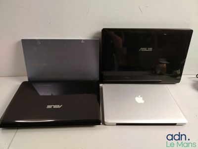 trois ordinateurs portables posés sur une table, dont l'un est ouvert et l'autre fermé