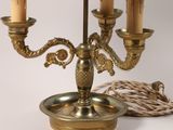 a brass candelab with three candles and a rope