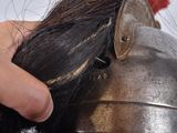 a person cutting a piece of hair with a scissors