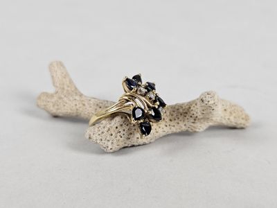 a close up of a ring on a piece of coral on a white surface