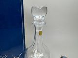 a glass bottle with a stopper sitting next to a blue box