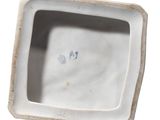 underside view of a white porcelain vase with a blue and white design on it