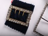 two pieces of jewelry that are laying on a table