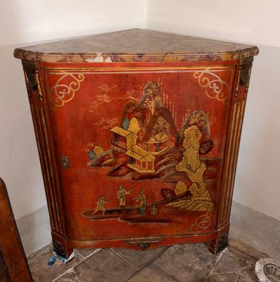 un meuble rouge orné d'un tableau, placé dans un coin