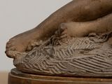 a statue of a woman laying down on a table