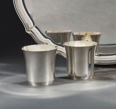trois tasses en argent et un plat en argent posés sur une table