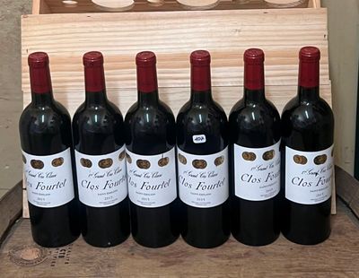 six bouteilles de vin rouge sont alignées devant une caisse en bois