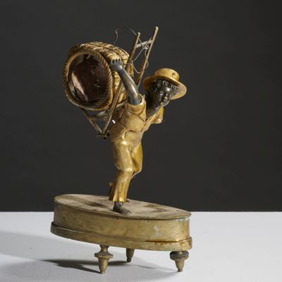 bronze statue of a man holding a basket on a stand