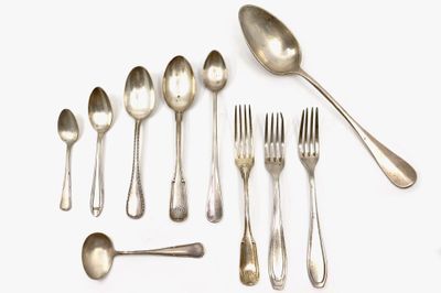 a lot of spoons and forks laid out on the table