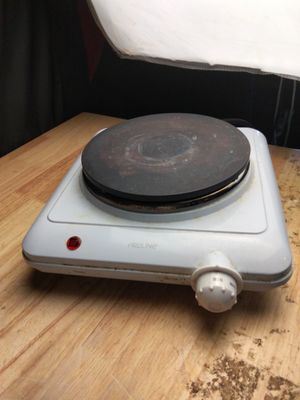 une cuisinière équipée d'un brûleur, posée sur une table en bois