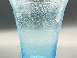 a blue glass cup sitting on top of a table