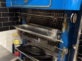 une photo d'une cuisine avec une grande cuisinière bleue