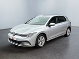 Une Volkswagen Golf argentée est garée dans une pièce blanche