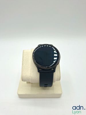 the watch is sitting on top of a stand on a white surface