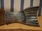 a metal fish sculpture on a wooden table