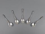 a set of five silver spoons and a spoon with a handle