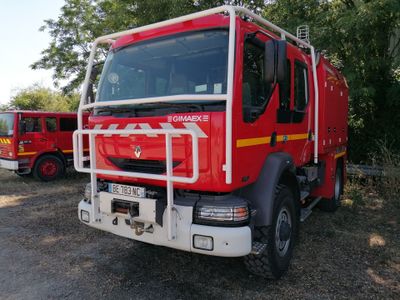 un camion de pompiers rouge garé à côté d'un autre camion de pompiers rouge