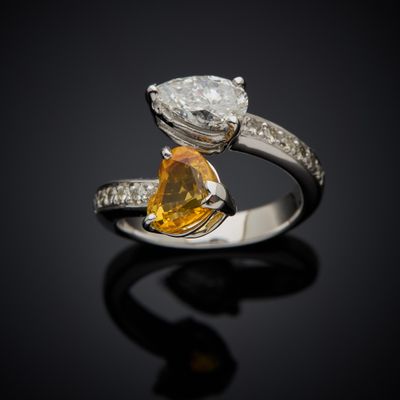 an engagement ring with a pear shaped diamond and a pear shaped yellow sapphire
