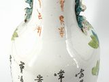 a white vase with asian writing on it on a black stand