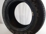 a close up of a tire on a white surface with a white curtain in the background