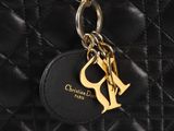 a close up of a black purse with a gold charm on it