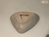 a stone sculpture of a triangular shaped object on a white surface