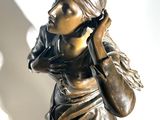 a bronze statue of a woman talking on a cell phone