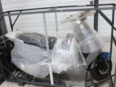 une moto emballée dans du plastique et rangée dans le garage