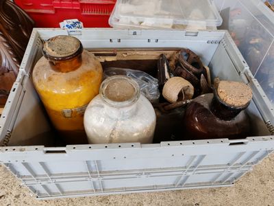 de nombreux bocaux, les uns à côté des autres, dans un récipient posé par terre