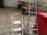 two ladders that are next to a red box
