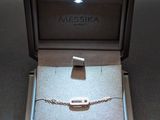 an open box with a bracelet inside of it on a table