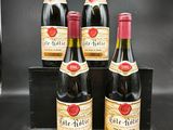 quatre bouteilles de vin sont posées sur une table noire