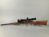 a rifle with a scope mounted on the side of it