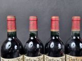 three bottles of red wine are lined up on a table