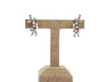 a close up of a pair of earrings on a stand